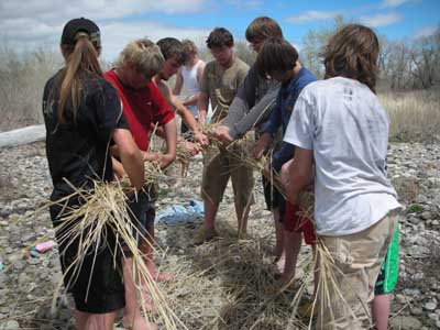 Students making a grass rope.