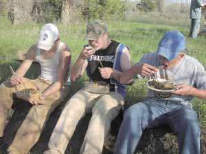 Students eating primitive stir fry meal.