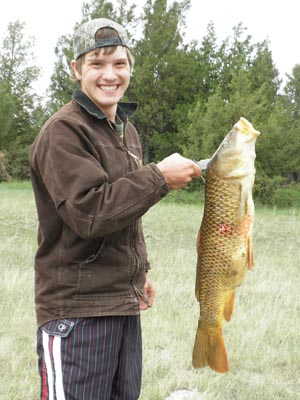Teenager with large carp fish.