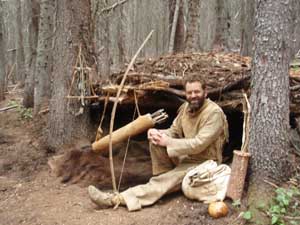 Thomas Elpel in buckskins at primitive shelter.