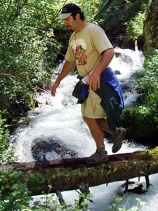Crossing mountain stream on log.