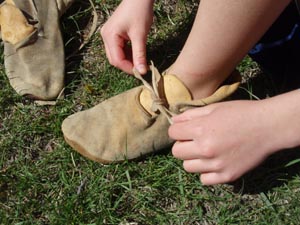 Trying on buckskin moccasins.